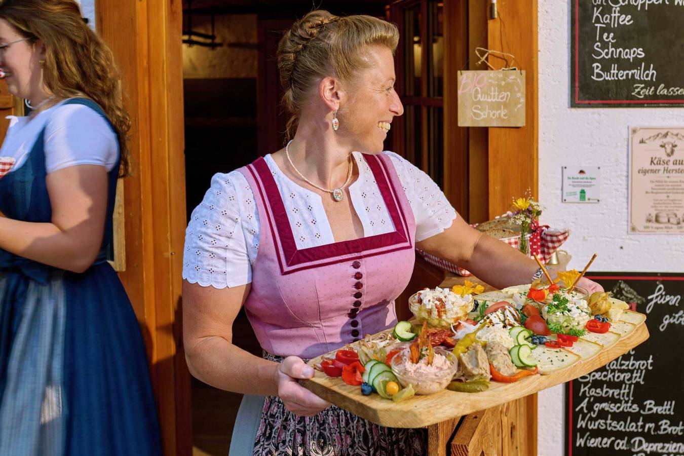 Traditionelles Almhandwerk das Gäste auf der Brotzeitplatte schmecken bei bester Bio-Qualität